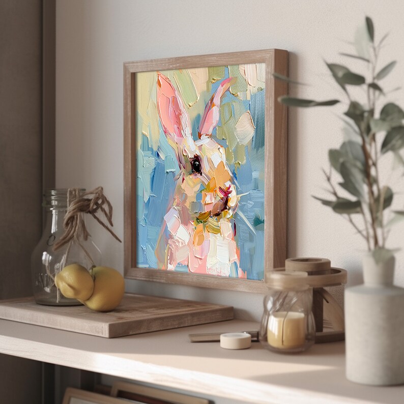 May include: A framed painting of a white rabbit with pink ears, painted in a colorful, impressionistic style. The rabbit's face is the focal point of the painting, with its eyes looking directly at the viewer.