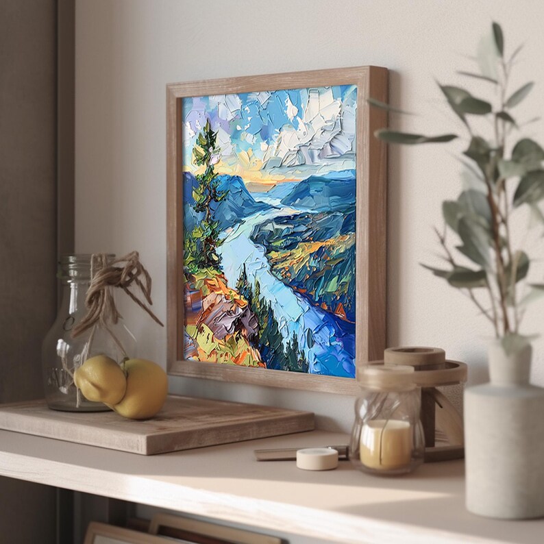 May include: A framed painting of a landscape with a river winding through a valley. The painting is done in a palette of blues, greens, and yellows, with a touch of orange. The river is a bright blue, and the valley is a mix of greens and browns. The sky is a light blue with white clouds.