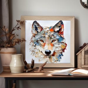 May include: A framed artwork featuring a textured, colorful painting of a wolf's face. The wolf's fur is depicted with thick brushstrokes in shades of white, blue, orange, and yellow. The eyes are a warm orange, and the frame is light wood.