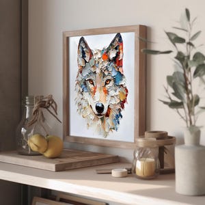 May include: A framed art print featuring a colorful, textured painting of a wolf's head. The artwork uses a palette of white, orange, blue, and red. The framed print is displayed on a shelf with decorative items, including a glass jar and a small candle.