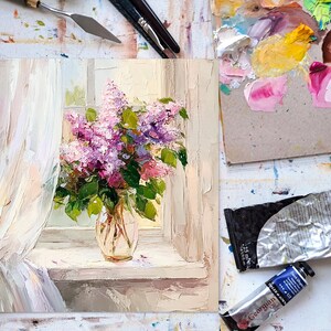 May include: A painting of a bouquet of purple lilacs in a clear glass vase on a windowsill. The lilacs are in full bloom and the vase is sitting on a white windowsill. The painting is done in a realistic style and the colors are soft and muted.