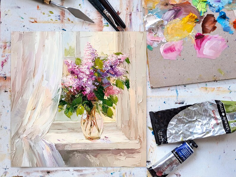 May include: A painting of a bouquet of purple lilacs in a clear glass vase on a windowsill. The lilacs are in full bloom and the vase is sitting on a white windowsill. The painting is done in a realistic style and the colors are soft and muted.