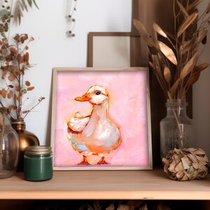 Op de afbeelding: Een ingelijst schilderij van een witte eend met een oranje snavel die op een roze achtergrond staat.