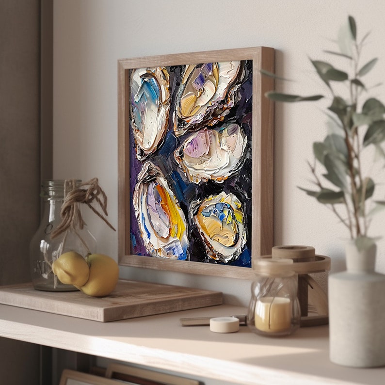 May include: A framed painting of oyster shells in various shades of white, yellow, and purple on a dark blue background. The painting is done in a textured style, giving the appearance of thick brushstrokes.