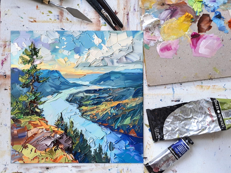 May include: A painting of a river winding through a valley with a mountain in the background. The sky is blue with white clouds. The painting is done in a thick, impasto style.