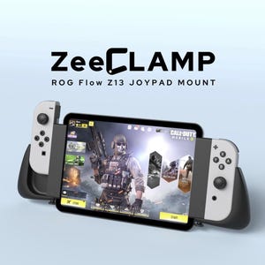 Può includere: Un supporto per gamepad ZeeCLAMP ROG Flow Z13 in bianco e nero che tiene un tablet che mostra un videogioco. Il tablet è affiancato da due controller di gioco bianchi e neri. Il gioco sullo schermo è Call of Duty Mobile.