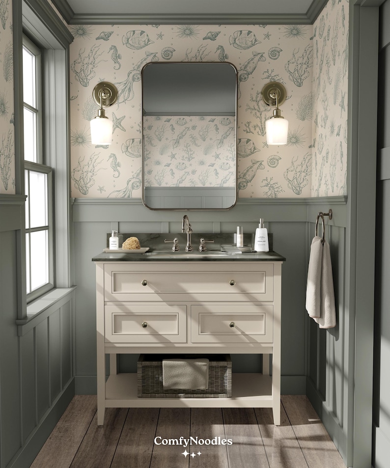 May include: A white bathroom vanity with three drawers and a lower shelf. The vanity has a black countertop with a sink and faucet. The walls are covered in a light blue and white wallpaper with a seahorse and seashell pattern. The vanity is in a bathroom with a green painted trim.