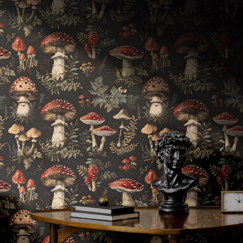 May include: Black and white wallpaper with a repeating pattern of red and white mushrooms and green foliage. A black bust of a man and a clock are on a wooden table in front of the wallpaper.