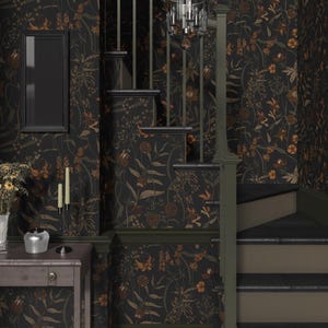 May include: A dark green and brown floral wallpaper with a black frame on the wall. A wooden staircase with a black railing leads up to the next level. A black chandelier hangs from the ceiling.