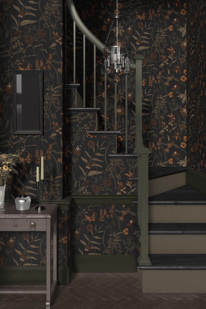 May include: A dark green and brown floral wallpaper with a black frame on the wall. A wooden staircase with a black railing leads up to the next level. A black chandelier hangs from the ceiling.