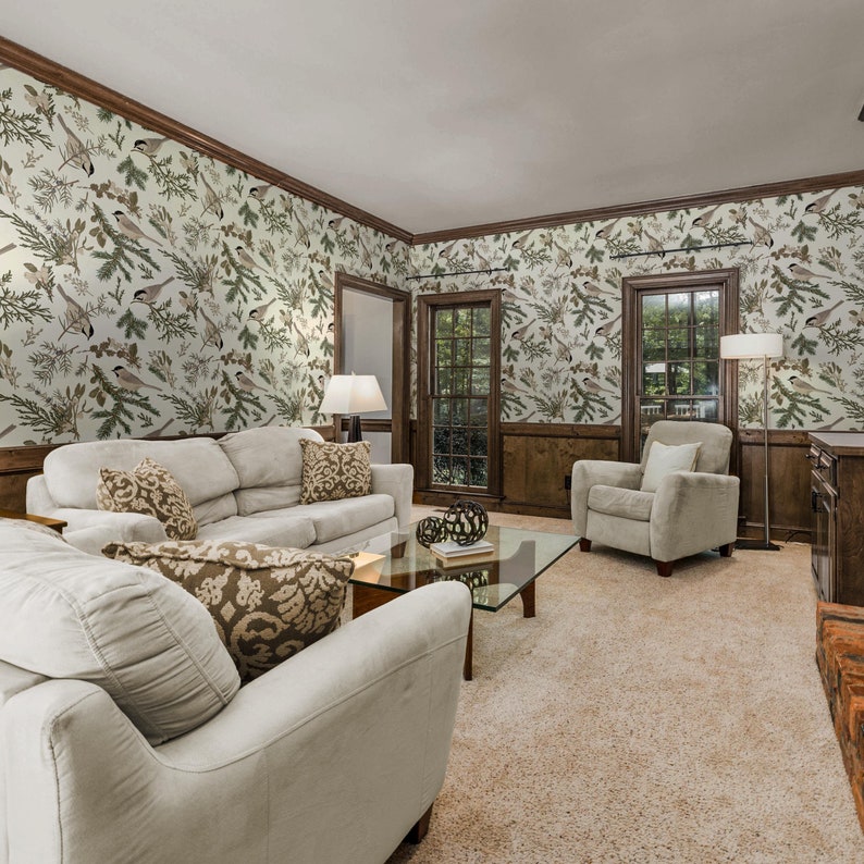 May include: A living room with beige carpet, two white sofas, a glass coffee table, and a brown armchair. The walls are covered in wallpaper with a pattern of birds and branches.