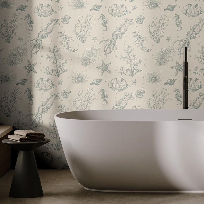 May include: A white bathtub with a light beige tiled wall featuring a repeating pattern of sea creatures, including seahorses, squid, starfish, and seashells. The pattern is in a light blue color.