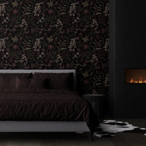 May include: A dark brown bed with a gray headboard and a dark brown duvet cover. The bed is in a room with a black wall and a fireplace. The wall has a floral wallpaper with dark green leaves and pink flowers.