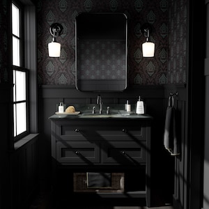 Puede incluir: Un tocador de ba&ntilde;o negro con un lavabo de porcelana blanca y un espejo encima. Las paredes est&aacute;n cubiertas con un papel tapiz de patr&oacute;n oscuro. El tocador tiene tres cajones y un estante debajo. Hay una toalla colgada en un estante a la derecha del lavabo.