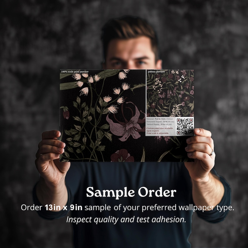 May include: A person is holding a sample order of wallpaper. The wallpaper is a dark floral pattern with pink and green flowers on a black background. The sample is 13 inches by 9 inches. The text on the sample reads "Sample Order" and "Order 13in x 9in sample of your preferred wallpaper type. Inspect quality and test adhesion."