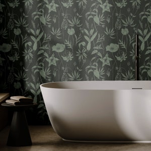 May include: A white freestanding bath with a floral patterned wallpaper backdrop. The wallpaper features a repeating pattern of green leaves and flowers.