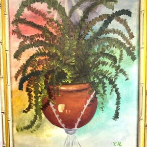Puede incluir: Pintura al óleo de un helecho colgante en una maceta de terracota. El helecho tiene frondas verdes, y la maceta está suspendida por cuerdas blancas sobre un fondo colorido de rosa, azul y amarillo. La pintura está enmarcada en un marco de estilo bambú.