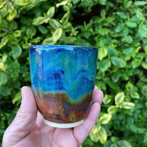 May include: A handmade wooden sign with the text "Welcome" in a handwritten style. The sign is painted white with a distressed finish, and a small green leaf is attached to the top. The sign is approximately 30 cm wide.