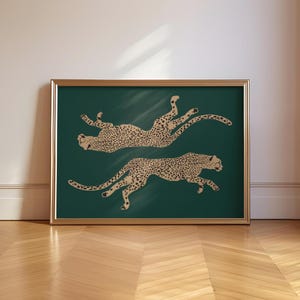 May include: A framed print of two cheetahs in a gold silhouette on a dark green background.