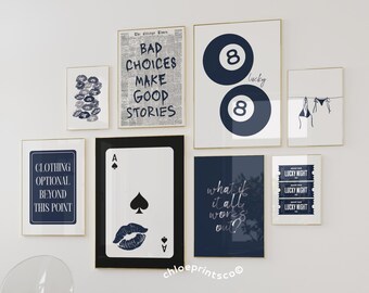 Puede incluir: Una colección de impresiones artísticas enmarcadas con varios diseños. Una impresión presenta el texto "CLOTHING OPTIONAL BEYOND THIS POINT". Otra muestra "BAD CHOICES MAKE GOOD STORIES". Otras impresiones incluyen un diseño de bola de billar, una carta de juego y el texto "what if it all works out?"