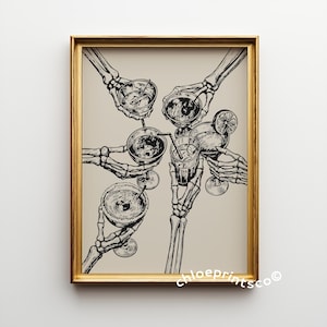 May include: A framed art print featuring a black and white illustration of skeletal hands holding various cocktails. The drinks include a cocktail with a lime slice, and drinks with straws. The artwork is set against a neutral background and framed in gold.