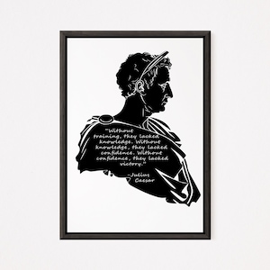 Puede incluir: Impresión enmarcada en blanco y negro que presenta una silueta de Julio César con una cita sobre el entrenamiento y la victoria. El diseño es minimalista, con texto claro. Una pieza elegante para la decoración del hogar.