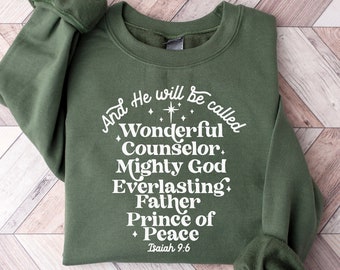 Può includere: Felpa verde militare con la scritta bianca "And He will be called Wonderful Counselor, Mighty God, Everlasting Father, Prince of Peace" tratta da Isaia 9:6. La felpa ha girocollo e maniche lunghe.