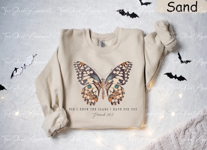 May include: A beige sweatshirt with a butterfly graphic and the text "For I know the plans I have for you Jeremiah 29:11".