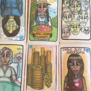 May include: A collection of hand-drawn tarot cards. The cards feature colorful illustrations and text, including "Emotional Pain," "Work, Labor, Efforts," "Abundance," and "Single Sexy & Successful." Each card has a unique design and number.