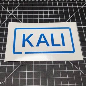 May include: A white sticker with a blue border and the word "KALI" in blue letters.