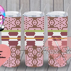 Pode incluir: Três copos de aço inoxidável de 20 oz com um design de favo de mel rosa e marrom. Os copos estão em um fundo de madeira. Dress Rhinestone Template Honeycomb 20oz SS16
