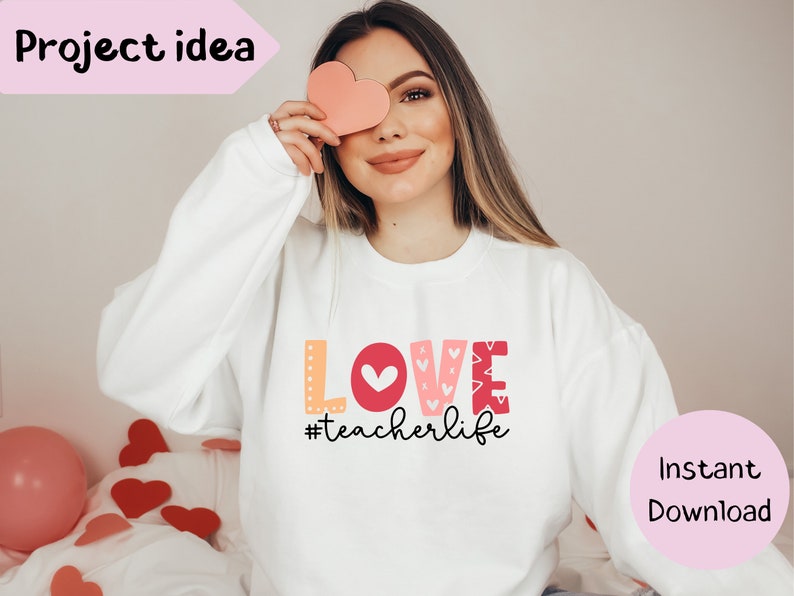 Pu&ograve; includere: Felpa bianca con una grafica rosa, rossa e arancione che dice "LOVE #teacherlife".