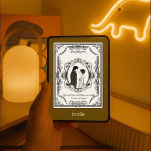 May include: A Kindle e-reader with a green border displays a black and white image of a couple in period clothing. The image is framed with ornate scrollwork and the text "You must allow me to tell you how ardently I admire and love you."