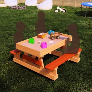 May include: A wooden sandbox table with two benches. The table has a light brown stain and the benches have a red stain. There are several toys in the sandbox, including a toy truck, a green box, and a pink box.
