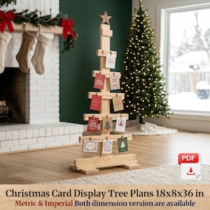 May include: A light-colored wooden Christmas tree-shaped card display stand with a star topper. The stand features horizontal slats with small clips holding various holiday cards. Text on the image reads: Christmas Card Display Tree Plans 18x8x36 in.