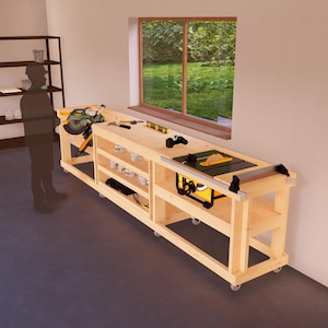 Könnte beinhalten: Eine Holzwerkbank mit einer Tischkreissäge, Regalen und Rollen. Die Werkbank ist aus unbehandeltem Holz und hat eine hellbraune Farbe. Die Tischkreissäge ist ein kleines, tragbares Modell mit einem schwarz-gelben Farbschema. Die Regale sind offen und bieten Stauraum für Werkzeuge und andere Gegenstände. Die Werkbank ist auf Rollen, wodurch sie leicht im Workshop bewegt werden kann.