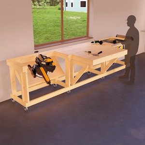 May include: A wooden workbench with a miter saw attached to the side. The workbench has wheels and is made of unfinished wood. The workbench is in a garage with a window in the background.