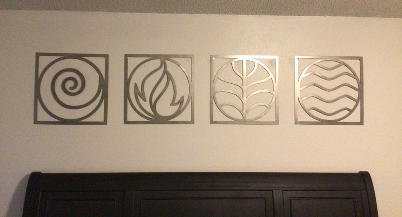 May include: Four metal wall decor pieces in the shape of squares with circles inside. Each circle features a different element: water, fire, earth, and air. The elements are stylized in a modern design.