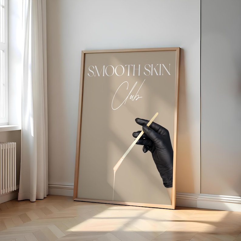 Op de afbeelding: Een beige poster met een gouden lijst met de tekst "SMOOTH SKIN Club" in witte letters. Een hand met een handschoen houdt een houten stok vast waar een witte substantie van druipt.