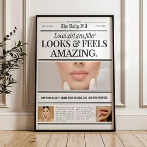 Puede incluir: Un p&oacute;ster enmarcado con el titular "Local girl gets filler LOOKS & FEELS AMAZING." La imagen presenta un primer plano de los labios de una persona con una jeringa. El p&oacute;ster est&aacute; en un marco negro y se muestra en un suelo de madera.
