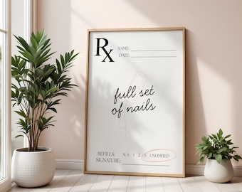 May include: A framed print with the text "full set of nails" in a script font. The print has a prescription-style design with lines for name, date, refills, and signature. The frame is a light wood color, and the background is a soft pink.