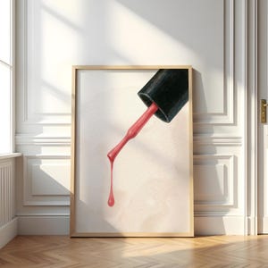 Puede incluir: Impresión enmarcada que presenta un primer plano de un frasco de esmalte de uñas negro y un pincel, con esmalte rojo vibrante goteando. La obra de arte está ambientada sobre un fondo neutro, creando una estética moderna y elegante.