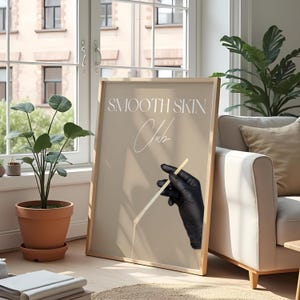 Op de afbeelding: Een beige poster met de tekst "SMOOTH SKIN Club" in witte letters. Een hand met een handschoen houdt een houten stok vast met een witte substantie die eraf druppelt.