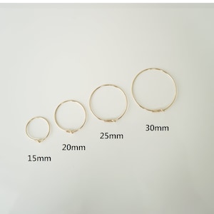 May include: Four gold hoop earrings of different sizes. The earrings measure 15mm, 20mm, 25mm, and 30mm in diameter.