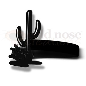 May include: Black silhouette of a tall cactus with smaller cacti at the base. The cactus is a popular desert plant and symbol of the American Southwest.
