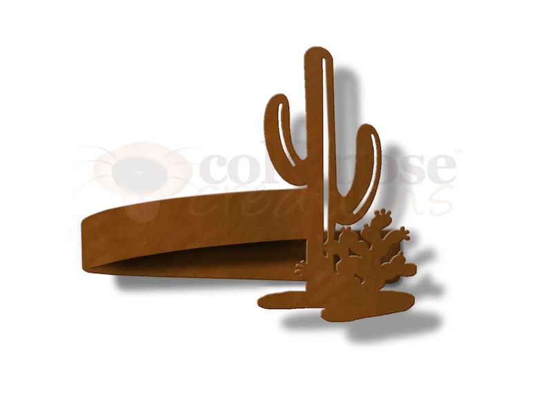 May include: Rustic brown metal cactus napkin ring. The ring is shaped like a tall cactus with smaller cacti at the base.