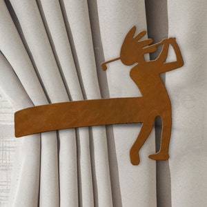 May include: A brown metal curtain tieback shaped like a golfer swinging a club. The tieback is holding back a set of white curtains.