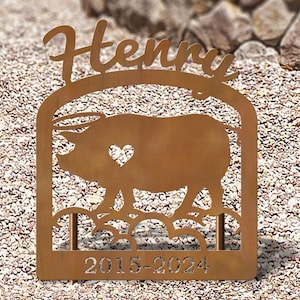 May include: A rusty metal memorial sign with a pig silhouette, a heart, and the name "Henry" above the dates "2015-2024".
