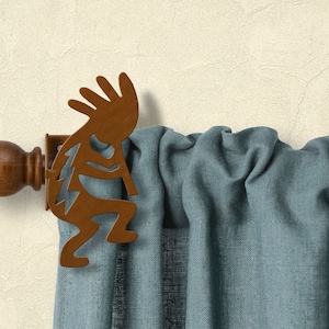 May include: A brown wooden finial with a metal Native American figure finial. The finial is attached to a curtain rod with a blue curtain.