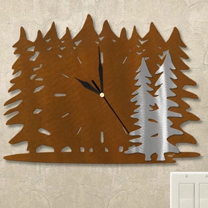 May include: A metal wall clock with a rustic brown finish, shaped like a forest of pine trees. The clock face is in the center of the design, with black hands and a silver-colored trim. The clock is mounted on a white wall with a light switch.